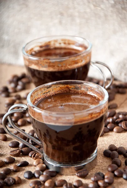 Due tazze di caffè nero su sfondo marrone — Foto Stock