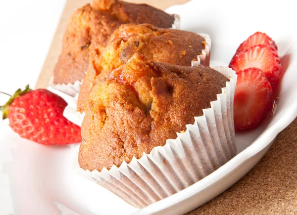 Strawberry muffin on a white plate with a fresh strawberry Royalty Free Stock Images