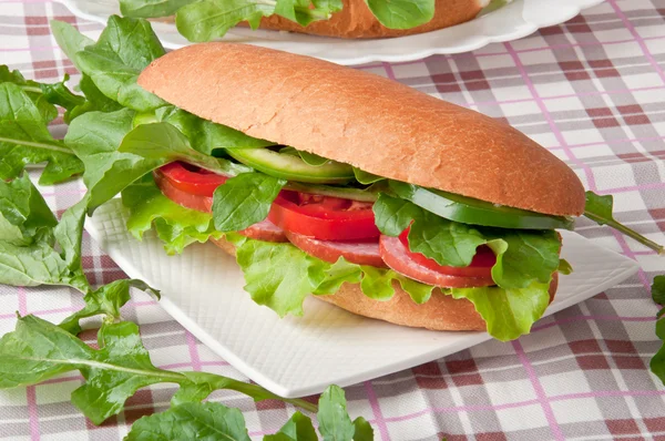 Sandwich met ham, rucola op de witte plaat, tomaat en komkommer — Stockfoto