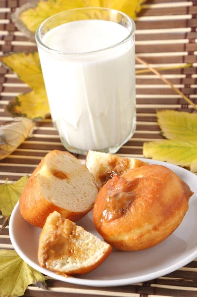 Завтрак. Стакан молока и пончика — стоковое фото