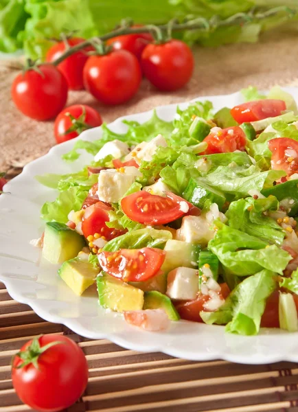 Salad with avocado, cherry tomatoes and mozzarella with honey-bacon dressing — Stock Photo, Image