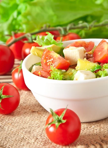 Salad with avocado, cherry tomatoes and mozzarella with honey-bacon dressing — Stock Photo, Image