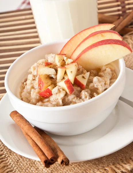 Oatmeal with apples and cinnamon in a white bowl — Stock Photo, Image