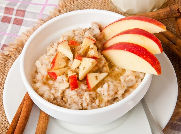 Harina de avena con manzanas y canela en un bol blanco —  Fotos de Stock