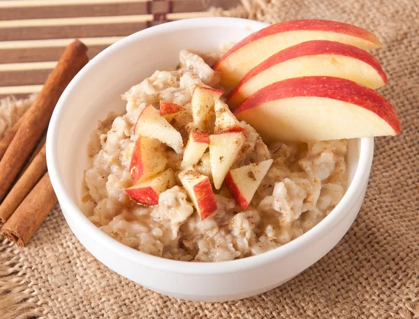 Harina de avena con manzanas y canela en un bol blanco — Foto de Stock