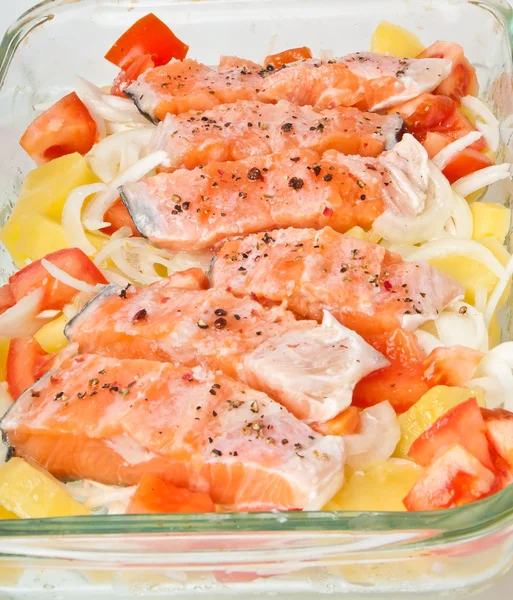 Pieces of salmon with potatoes, tomatoes and onions prepared for baking in the form — Stock Photo, Image