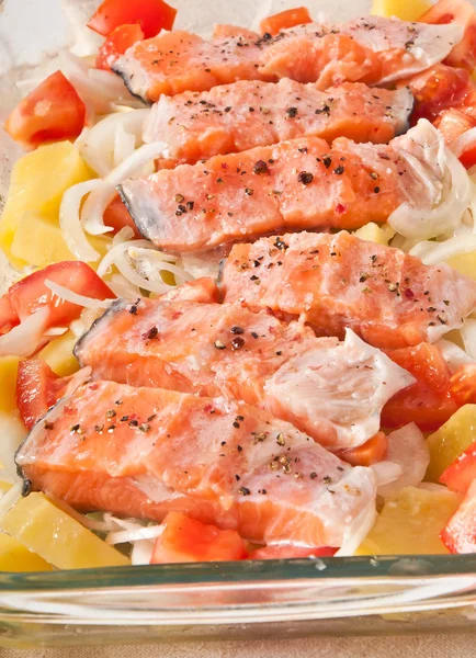 Pedaços de salmão com batatas, tomates e cebolas preparados para assar na forma — Fotografia de Stock