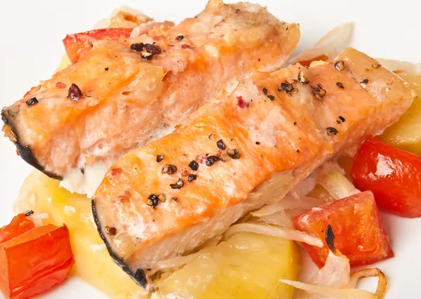 Pieces of salmon with potatoes, tomatoes and onions baked in the oven — Stock Photo, Image