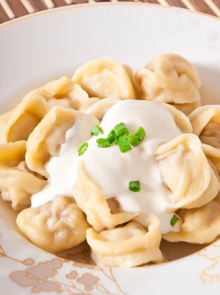 Raviolis rusos nacionales con crema agria en un plato — Foto de Stock