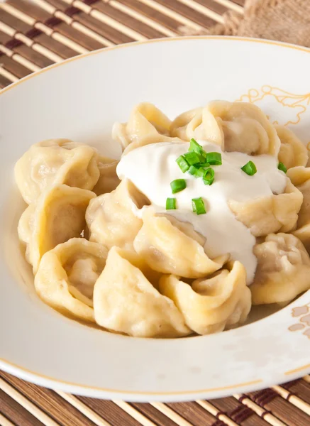 Raviolis rusos nacionales con crema agria en un plato — Foto de Stock