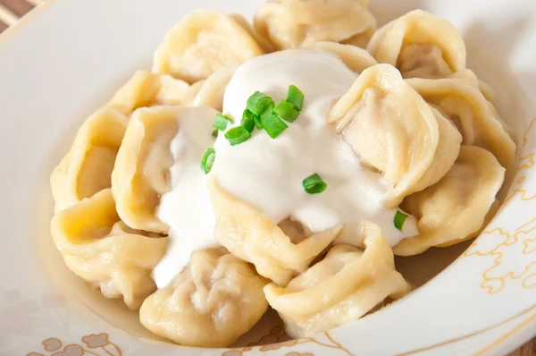 Russian national ravioli with sour cream on a plate — Stock Photo, Image