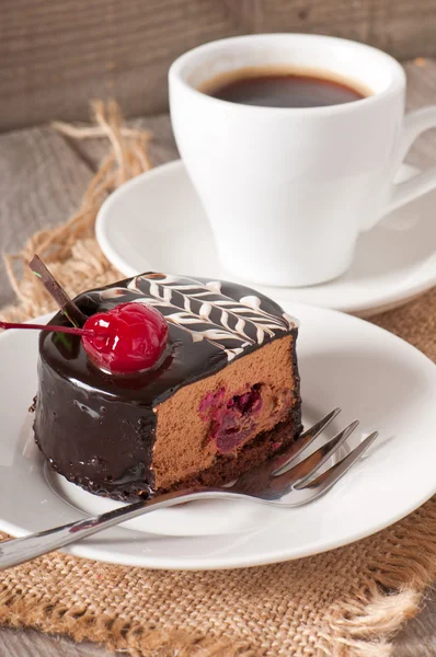 Süßes Dessert Obstkuchen mit einer Kirsche und einer Tasse Kaffee — Stockfoto