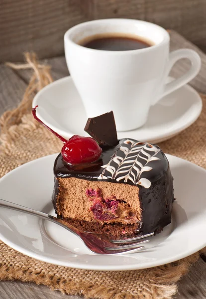 Tarta de postre dulce con una cereza y una taza de café —  Fotos de Stock