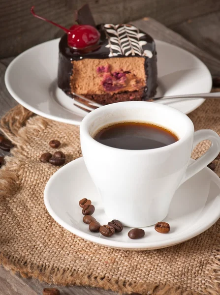 Tarta de postre dulce con una cereza y una taza de café — Foto de Stock