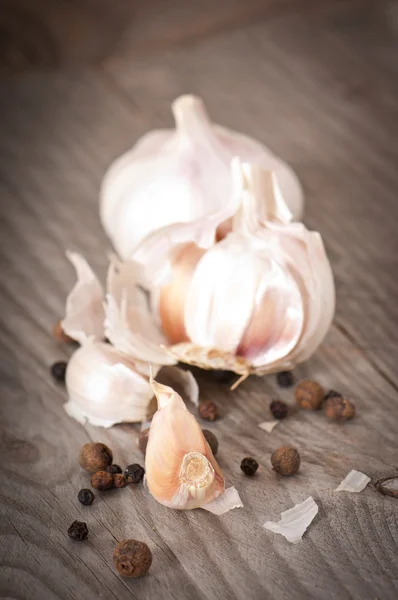Garlic and pepper on a wooden background — Stock Photo, Image