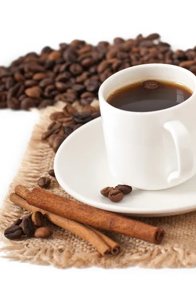 Closeup view of a cup of coffee and coffee beans — Stock Photo, Image