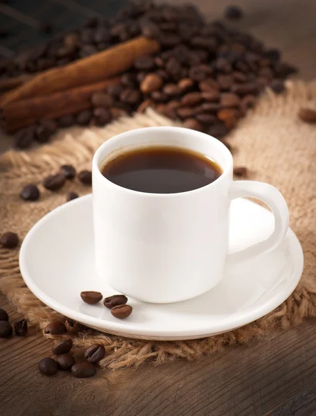 Closeup view of a cup of coffee and coffee beans — Stock Photo, Image