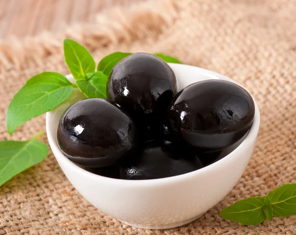 Black olives on a wooden table — Stock Photo, Image