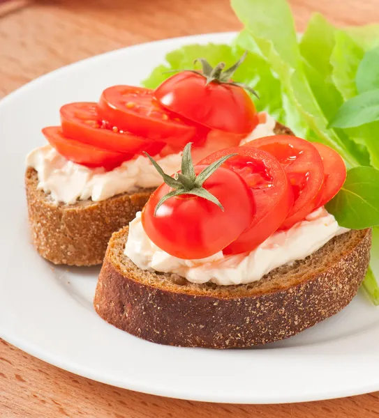 Varma bröd tomater, färskost och basilika — Stockfoto