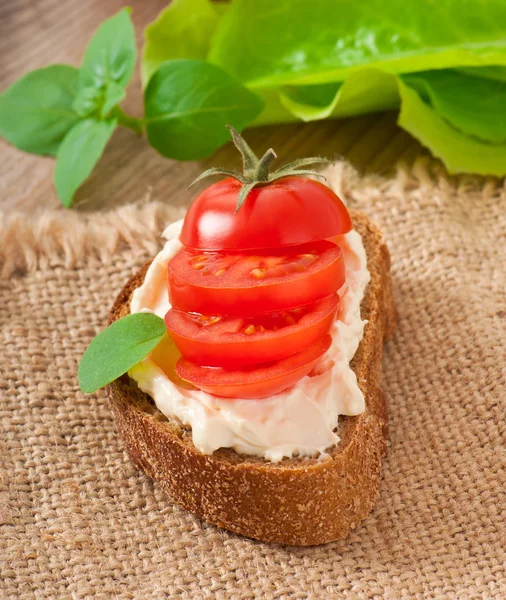 Teplý chléb rajčata, smetanovým sýrem a bazalkou — Stock fotografie