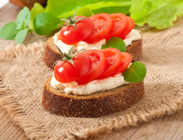 Roomkaas, warme brood tomaten en basilicum — Stockfoto