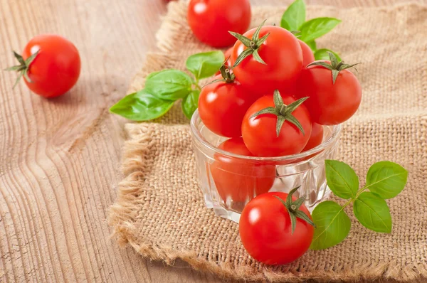 Cherry tomatoes in a bowl with basil — Stock Photo, Image