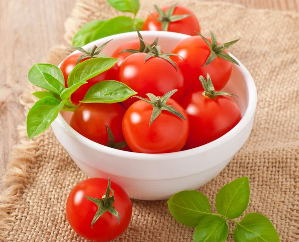 Kirschtomaten in einer Schüssel mit Basilikum — Stockfoto