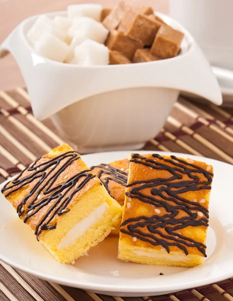 Slice of sponge cake with tea and sugar — Stock Photo, Image