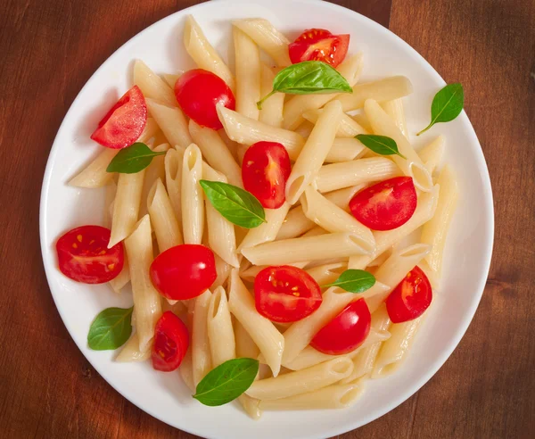 Pasta salad with cherry tomatoes and fresh basil leaves — Stock Photo, Image