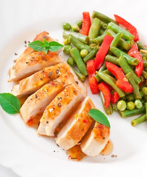 Chicken breast with vegetables and sauce decorated with basil leaves — Stock Photo, Image