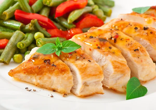 Chicken breast with vegetables and sauce decorated with basil leaves — Stock Photo, Image