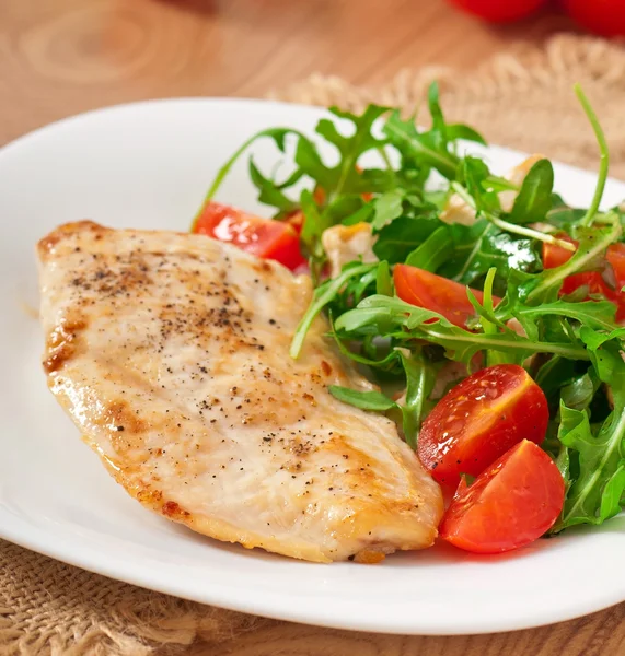 Gegrilltes Hühnerfilet und ein Salat mit Rucola und Tomaten — Stockfoto