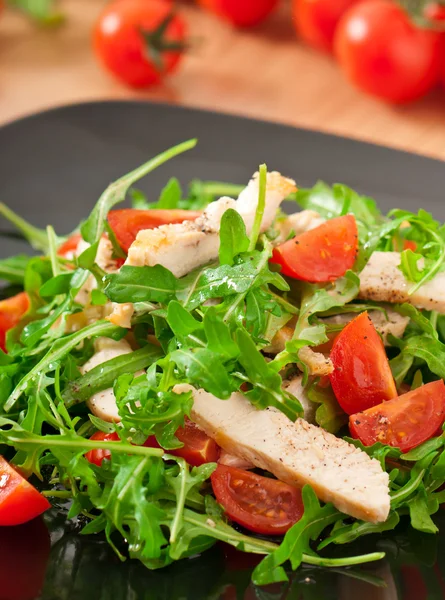 Filet de poulet grillé et salade de roquette et tomate — Photo