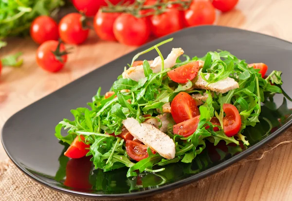 Filé grelhado de frango e uma salada de rúcula e tomate — Fotografia de Stock