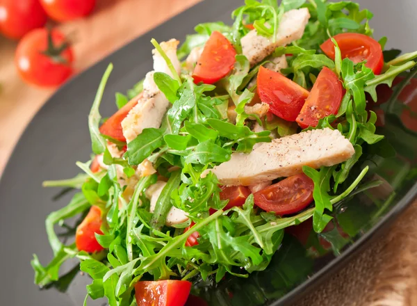 Gegrilde filet van kip en een salade van rucola en tomaat — Stockfoto