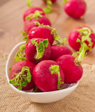 ahşap masa üzerinde beyaz kase taze turp