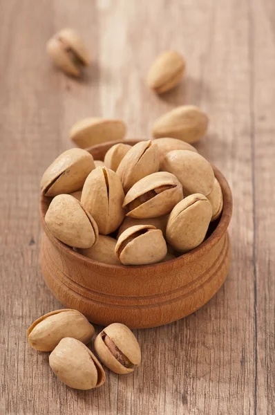 Cracked and Dried Pistachio Nuts In A Wooden Bowl — Stock Photo, Image