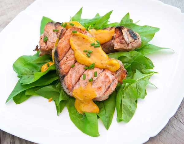 Grilled salmon on spinach pillow with orange-mustard sauce — Stock Photo, Image