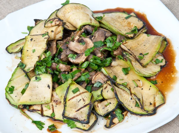 Slices of zucchini and mushrooms grilled in a sauce — Stock Photo, Image