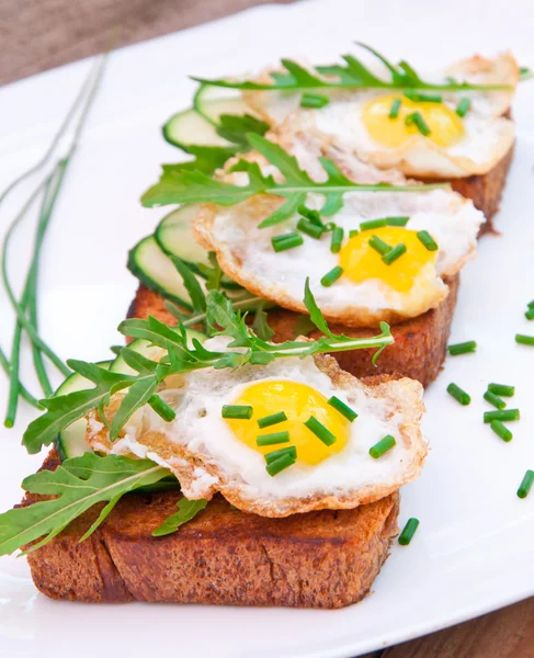 Torrada com ovo frito, pepino e arugula — Fotografia de Stock