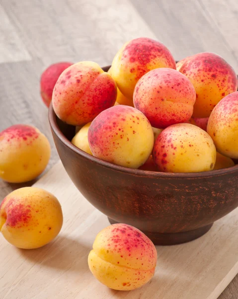 Чаша свежих абрикосов на деревянном столе — стоковое фото