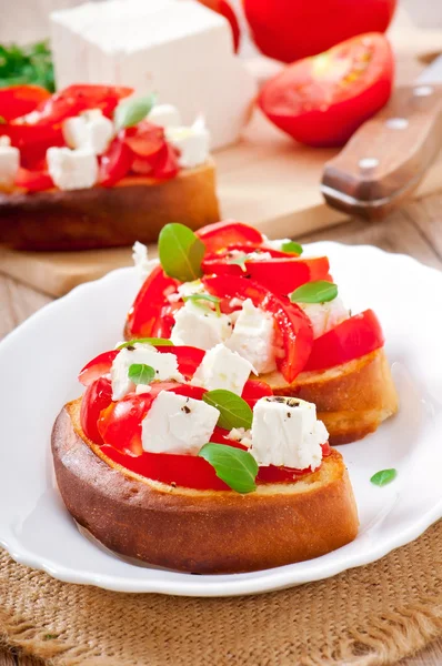 Bruschetta s rajče, sýr feta a čerstvou bazalkou — Stock fotografie