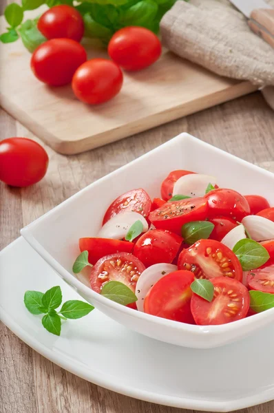 Tomatkörsbärssallad med basilika, svartpeppar och lök — Stockfoto