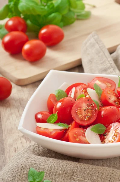 Rajčatový cherry salát s bazalkou, černým pepřem a cibulí — Stock fotografie