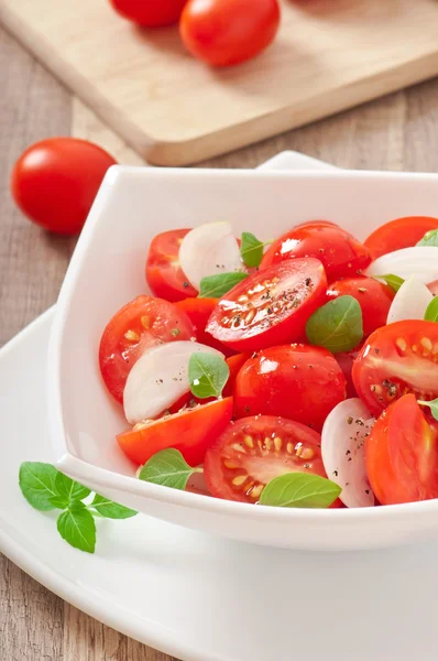 Tomatkörsbärssallad med basilika, svartpeppar och lök — Stockfoto