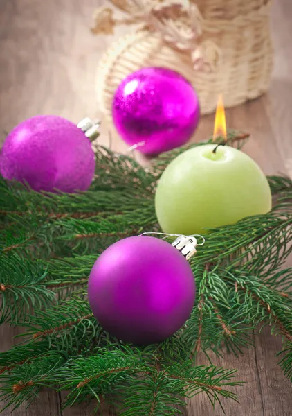 Christmas card with Christmas balls and a burning candle — Stock Photo, Image