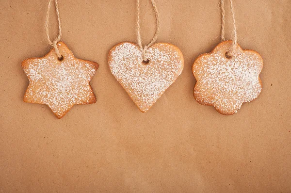 Lebkuchen, der auf einem Papierhintergrund hängt. Weihnachtsdekoration. — Stockfoto