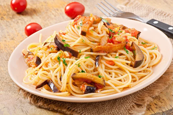 Спагетти с жареными баклажанами и помидорами и сладким и кислым соусом — стоковое фото