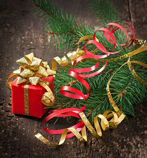 圣诞礼物和冷杉树枝上的旧的木制背景 — 图库照片