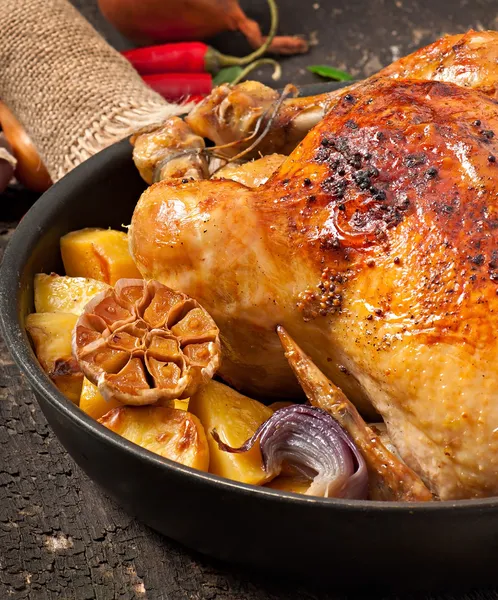 Pollo intero al forno con patate, aglio e cipolla — Foto Stock